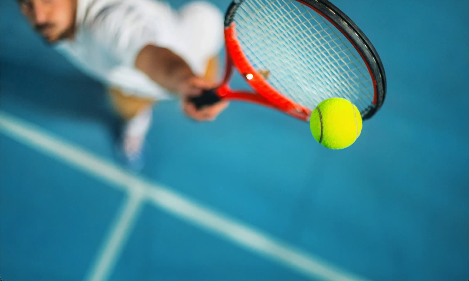 A player serving on a blue tennis court